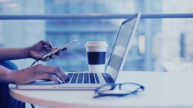 Laptop and mobile phone being used