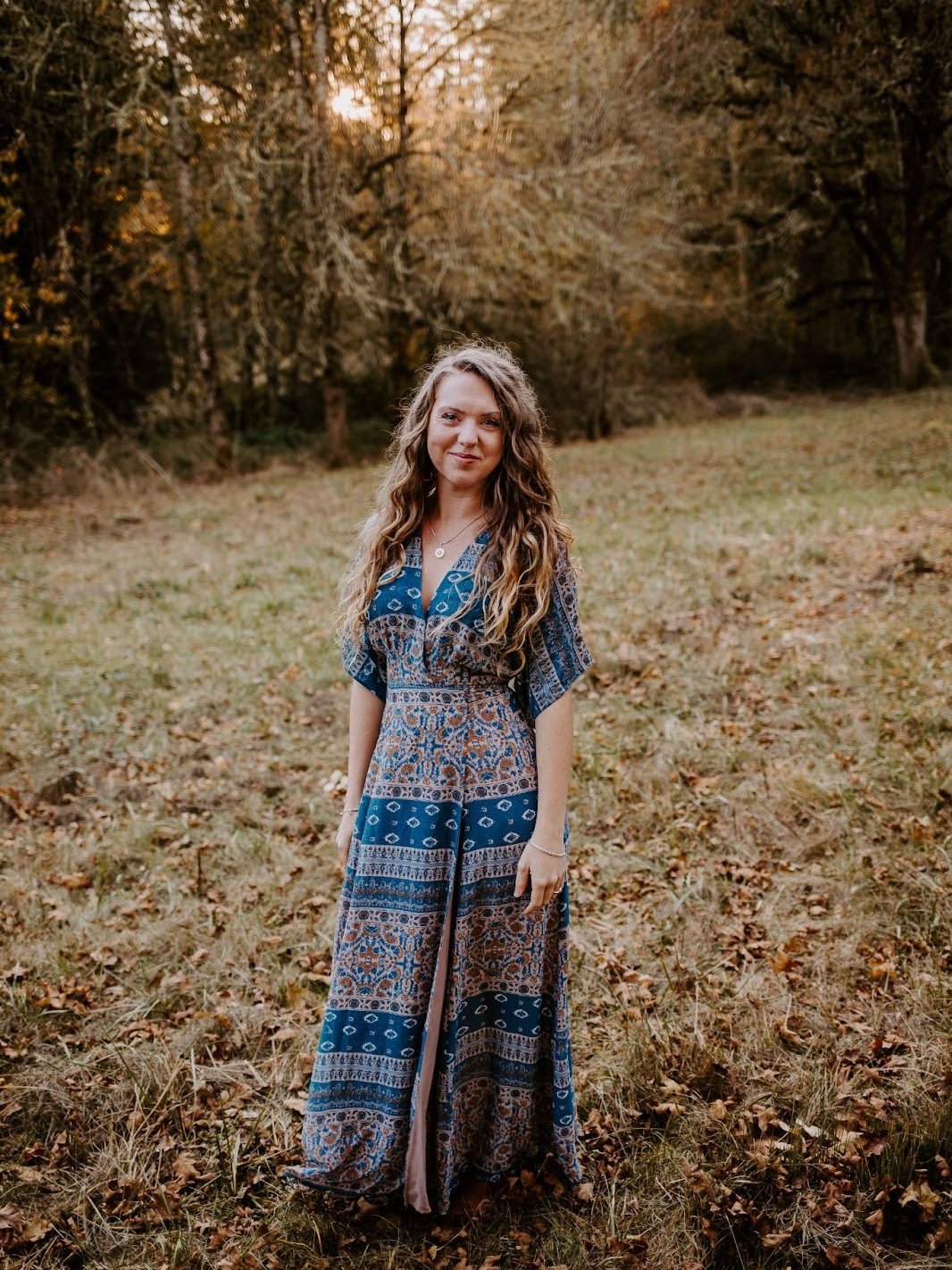 Mrs. Robles in a dress standing in a grass field